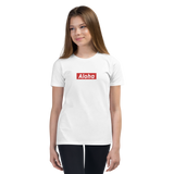 Preteen model wearing a Aloha Tribe Hawaii T-shirt that has a Hawaii themed graphic logo on the front.