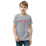 Preteen model wearing a Aloha Tribe Hawaii T-shirt that has a Hawaii themed graphic logo on the front.