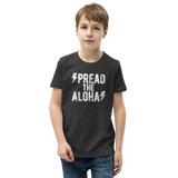 Preteen model wearing a Aloha Tribe Hawaii T-shirt that has a Hawaii themed graphic logo on the front.