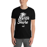 Young male adult wearing a Alter Ego Hawaii T-shirt that has a Hawaii themed graphic logo on the front.