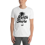 Young male adult wearing a Alter Ego Hawaii T-shirt that has a Hawaii themed graphic logo on the front.