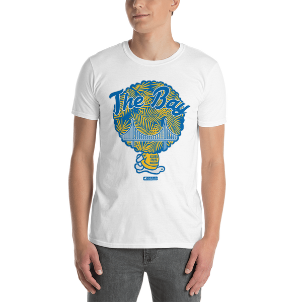 Young male adult wearing a Alter Ego Hawaii T-shirt that has a Hawaii themed graphic logo on the front.