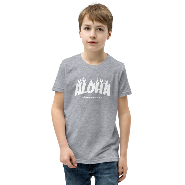 Preteen model wearing a Aloha Tribe Hawaii T-shirt that has a Hawaii themed graphic logo on the front.