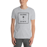 Young male wearing a Aloha Tribe T-shirt that has a Hawaii themed graphic logo on the front.