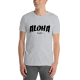 A male model wearing a Aloha Tribe Hawaii T-shirt that has Hawaii themed graphic logos on the front.